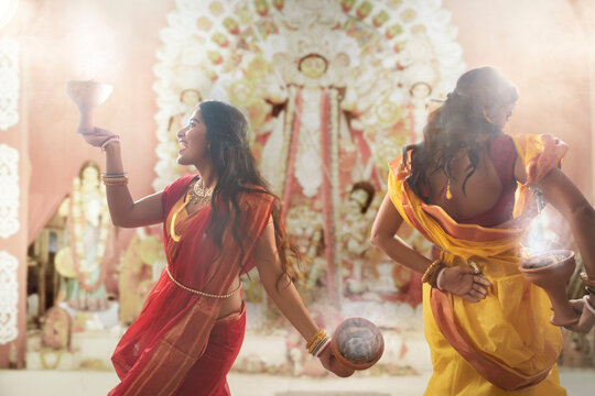 Two Married bengali women performing dhunuchi dance on the occasion of durga puja