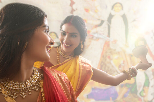 Two Married bengali women performing dhunuchi dance on the occasion of durga puja