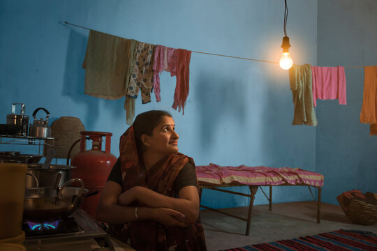 Indian Woman Cooking Food Looking At Light Bulb