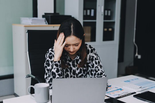 Tried young Asian office employee feeling sick and have a headache from a long working day at office