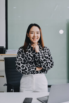 Confident asian business woman standing in modern office