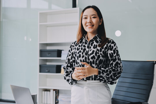 Confident asian business woman standing in modern office