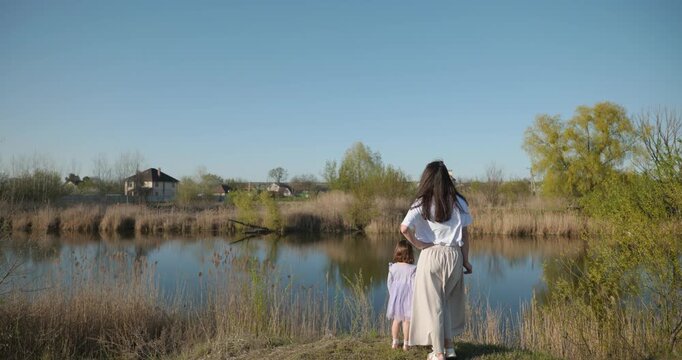 Young mother with child daughter spend time playing enjoying nature. 4K 10-bit