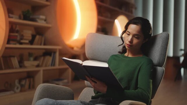 Relaxed young Korean woman reading book in university library, enjoying hobby
