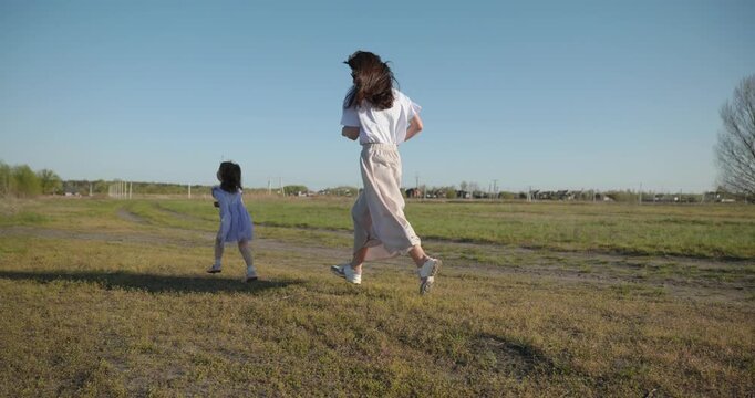 Young mother with child daughter spend time playing enjoying nature. 4K 10-bit