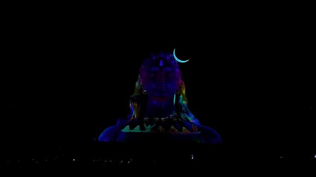 View of Adiyogi shiva statue illuminated by spectacular 3D laser light show at night