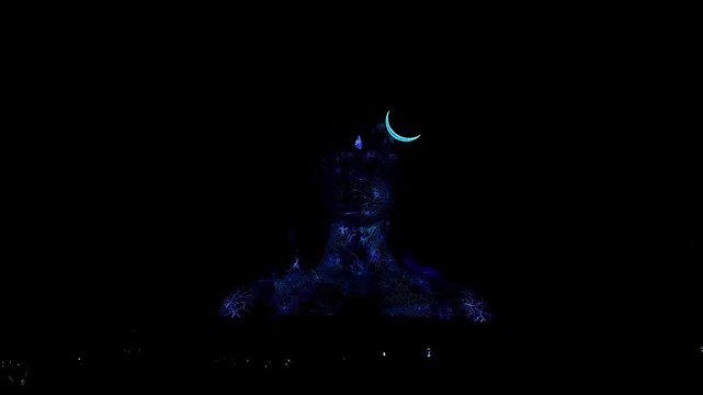 View of Adiyogi shiva statue illuminated by spectacular 3D laser light show at night