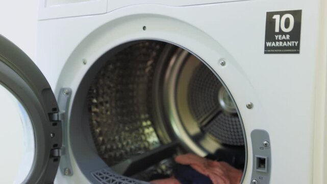 A close-up of a front-load washing machine and dryer stacked or placed together in a home laundry room setting.