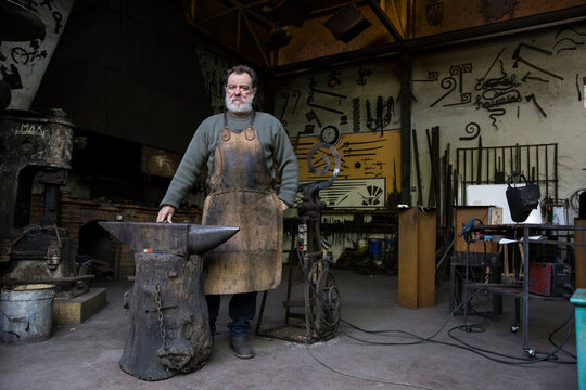 Portrait of confident blacksmith in his workshop
