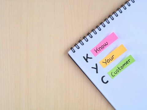 KYC (Know Your Customer) with colorful adhesive notes on wooden table. Representing business strategy, identity verification, compliance regulations, client relationship, and audience research