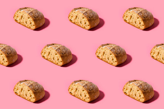 Pattern of fresh loaves of bread against pink background