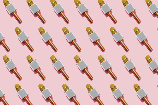 Pattern of golden microphones against pink background