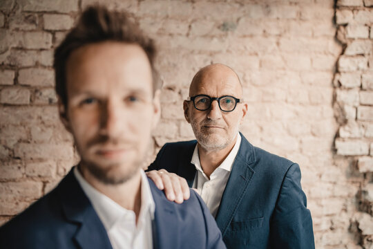 Portrait of senior businessman behind and mid-adult businessman