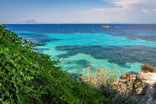 Vacationers swimming and snorkeling in the beautiful turquoise waters of Favignana beach in Sicily