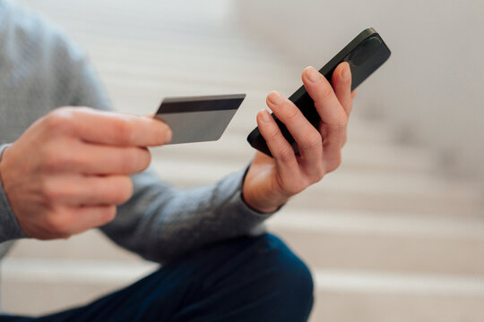 Hands of businessman holding credit card and smart phone