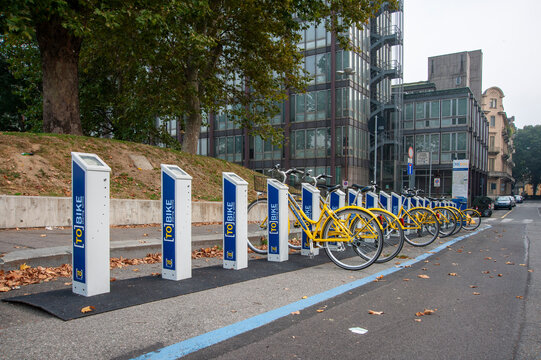 Torino, Italia - 28/09/2014  Stazione di bike sharing con biciclette gialle in una via urbana. Immagine che rappresenta mobilit&agrave; sostenibile, servizi pubblici e vita cittadina contemporanea.