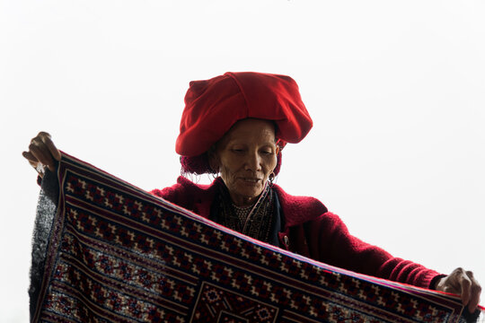 Artisan displaying traditional patterned textile in Sapa Vietnam