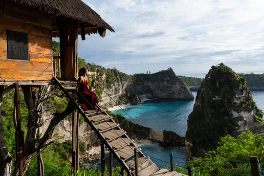 Woman views Diamond beach from a treehouse in Nusa Penida