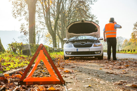 Back view of man on cell phone having a car breakdown