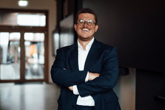 Smiling businessman with freckles shows confidence in the office