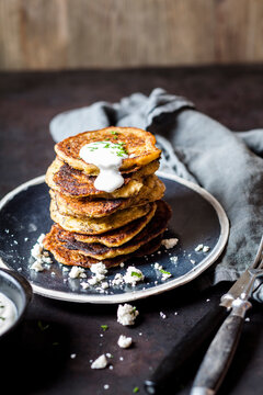 Stack of zucchini fritters with garlic yogurt sauce and feta