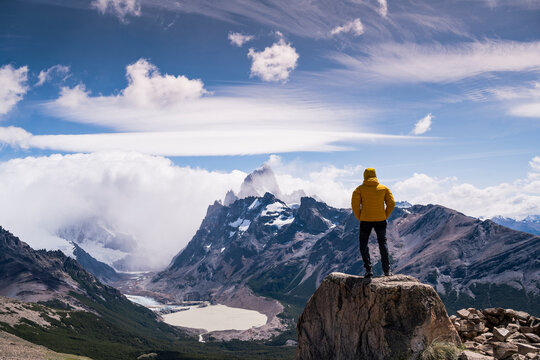 Hiker in yellow jacket admiring Mount Fitz Roy in Patagonia