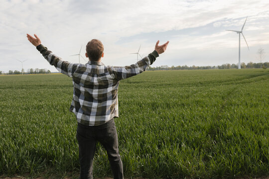 Man celebrates renewable energy in a green countryside field