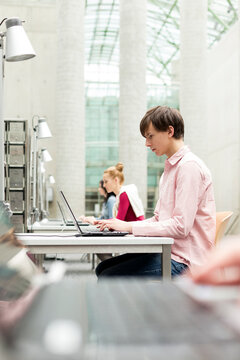 Students using laptops in a university library