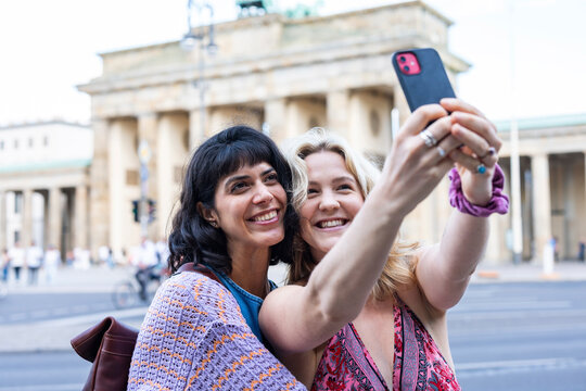 Female friends take a selfie at the Brandenburg Gate in Berlin
