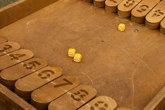 Yellow Dice Rolled on Wooden Shut the Box Board Game