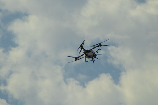 Agricultural Multirotor Spraying Drone Flying in Cloudy Sky