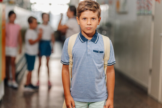 Schoolboy feeling lonely and excluded in school hallway