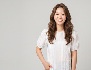Fototapeta premium A beautiful young Asian woman in a white shirt smiling warmly