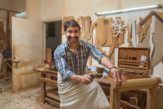 Carpenter working in his workshop with a hammer.
