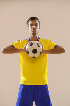 Football player holding football with both hands .