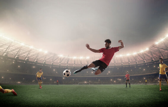 Football player kicking in front of floodlights