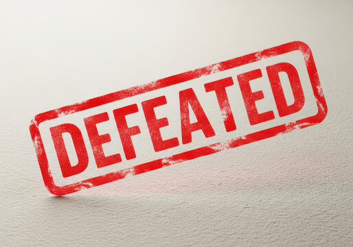 Red rubber stamp with the word Defeated printed on a textured paper surface