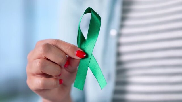 Woman Holds A Teal Ribbon In Her Palm