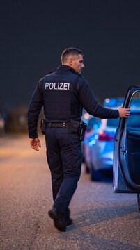 Polizist eilt zur ge&ouml;ffneten Fahrzeugt&uuml;r in der Untersicht