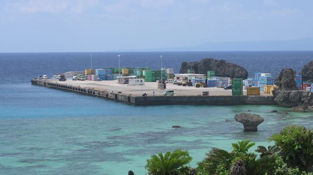 与論港とエメラルドグリーンの美しい海に並ぶコンテナの風景