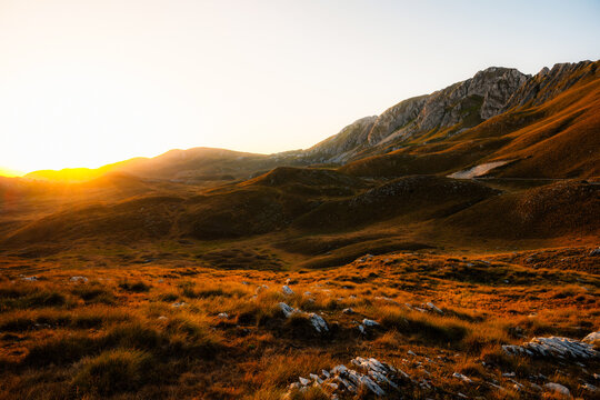 Grand panoramic view from Prutas peak at sunset, overlooking the dramatic limestone ridges and deep valleys of Durmitor National Park, Montenegro.
