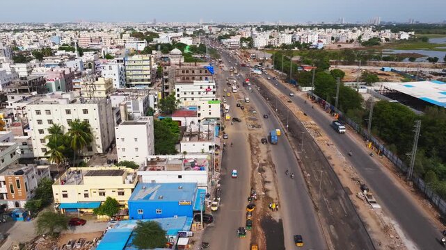 residential buildings with under construction national highway 65 and vehicles at Patancheruvu, hyderabad, telangana, india. day time, push in shot, drone shot, 4k.