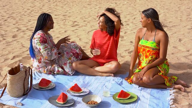 Happy group of multiracial women having fun eating watermelon during summer beach vacation - Holiday, picnic and young diverse people concept