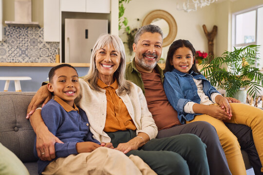 Happy multiethnic grandparents with grandchildren sitting on sofa