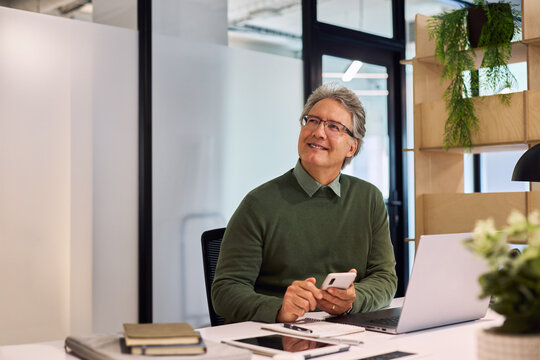 Businessman looking up and thinking at office