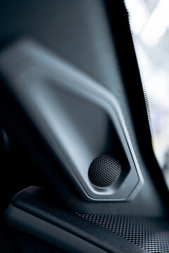 Car interior featuring a modern audio speaker detail, highlighting automotive design, technology, and sound system components