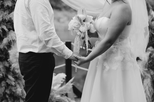 Couple exchanging vows, holding hands, and sharing a moment of commitment and love on their wedding day