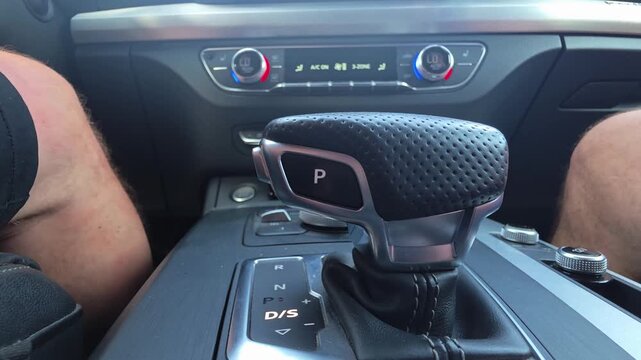 Car interior showing automatic gear shift in drive sport mode, dashboard climate control display indicating low temperature, modern vehicle console design.
