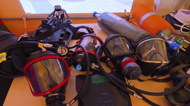 Collection of advanced respiratory protection equipment for emergency response, including full-face masks, air tanks, and self-contained breathing apparatus components prepared for critical operations