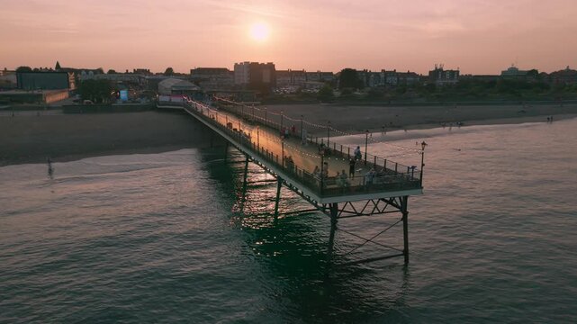 Coastal sunset seaside holiday resort of Skegness on the east coast of Lincolnshire UK, English vacation and sweeping vista views. Evening nightlife with Big Wheel rides and amusements. Pier and town
